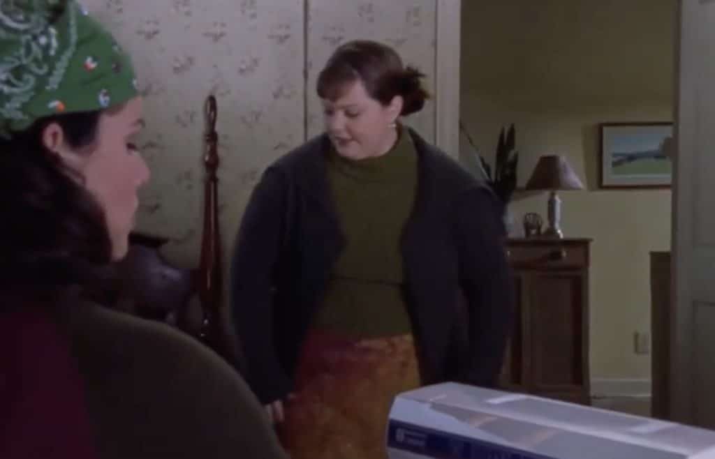 sookie st. James seen wearing a green top, warm colored skirt, and brown jacket